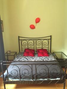 1 cama con almohadas rojas y un globo rojo en la pared en Apartament PIĘKNA, en Varsovia