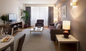 リスボンにあるAltis Suites Apartamentos Turísticosのリビングルーム(ソファ、テーブル付)