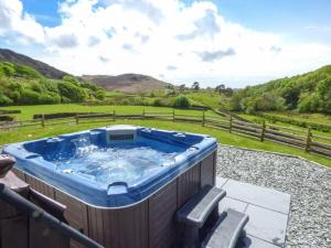 einen Whirlpool auf einer Terrasse mit Blick auf ein Feld in der Unterkunft Copper Beech Cottage in Coniston