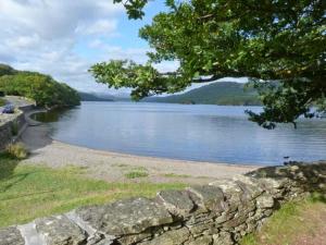 eine Steinmauer neben einem Wasserkörper in der Unterkunft Copper Beech Cottage in Coniston + 11 Fotos