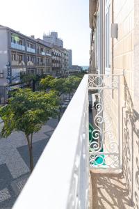 a balcony with a white railing and a tree at Botica Guesthouse in Espinho