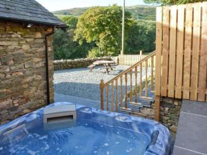 eine Whirlpool-Badewanne im Hof neben einer Treppe in der Unterkunft Yew Tree Cottage in Coniston