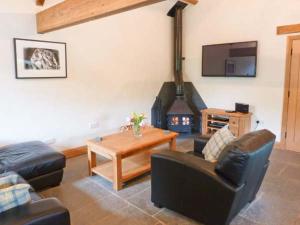 ein Wohnzimmer mit Sofas, einem Tisch und einem Kamin in der Unterkunft Yew Tree Cottage in Coniston + 6 Fotos