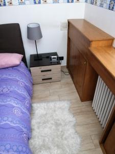 Schlafzimmer mit einem Bett, einem Schreibtisch und einem Teppich in der Unterkunft Rue de Vachery 46 in Etroubles