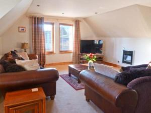 a living room with two couches and a television at An Torr in Newtonmore