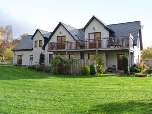 a large house with a large yard with green grass at An Torr in Newtonmore