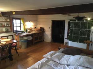 a bedroom with a bed and a kitchen with a table at Chalupa U Vincků in Stachy