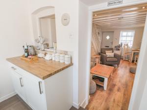a kitchen with a counter and a living room at Kirrin Cottage in Conwy