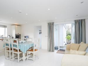 een witte keuken en een woonkamer met een tafel en stoelen bij Hafod, Llangoed in Llangoed