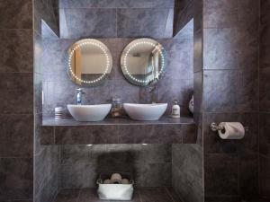 a bathroom with two sinks and two mirrors at Kilcarreg in Wadebridge +30 photos