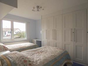 a bedroom with two beds and a window at Godolphin in Wadebridge