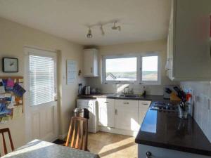 a kitchen with white cabinets and a counter top at Godolphin in Wadebridge