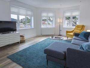 een woonkamer met een bank en een tv bij 3 Church Hill House in Salcombe