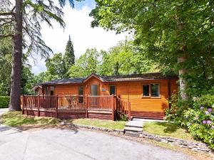 a log cabin with a porch and a house at Beech Hill Lodge Beech Hill 9 at Fallbarrow Park in Windermere