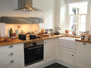 a kitchen with white cabinets and a stove top oven at Beck Steps 1 in Grasmere
