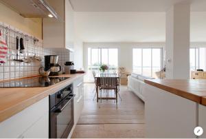 uma cozinha com um balcão e uma sala de jantar em Aux 4 Sardines T2 56m2 em Concarneau