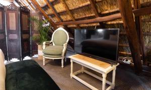 a living room with a flat screen tv and a chair at Weltevreden Estate in Stellenbosch