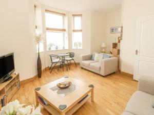 a living room with a couch and a table at Gwylanedd One in Llanfairfechan