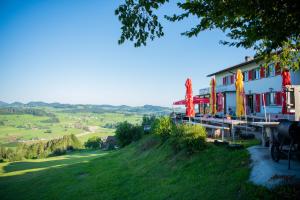 Ganterschwil的住宿－Restaurant und Kaeserei Berghof，山丘上享有田野景色的建筑