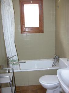 a bathroom with a tub and a toilet and a window at Apartamento a pie de pistas La Molina con vistas in La Molina