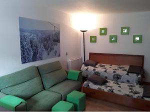 a living room with a couch and a bed at Apartamento a pie de pistas La Molina con vistas in La Molina