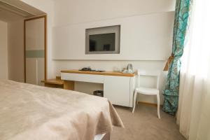 a bedroom with a bed and a desk with a sink at Gardenia Hotel & Spa in Veles