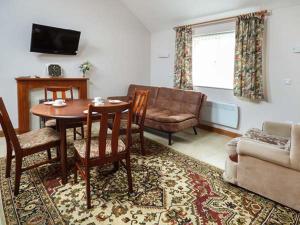 a living room with a table and a couch at Ysgubor in Llanelli