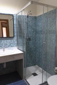 uma casa de banho com uma cabina de duche em vidro e um lavatório. em Hotel Rural Luna Llena em Torremocha de Jarama