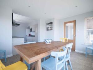 a dining room with a wooden table and chairs at Chynoweth in Crantock