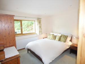 En eller flere senge i et værelse på Woodland Cottage