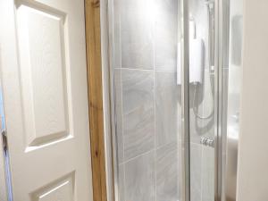 a shower with a glass door in a bathroom at Woodland Cottage in Stafford