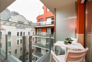 een appartement met een balkon met een tafel en stoelen bij BUDAPEST DOWNTOWN Residences - AC,ELEVATOR,TERRACE in Boedapest