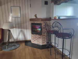 ein Wohnzimmer mit einem Kamin mit 2 Stühlen und einem TV in der Unterkunft gîte du bien être in Hodeng-Hodenger