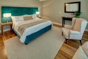 um quarto com uma cama grande e uma cadeira em Number 15 Ocean & City View Villas no Funchal