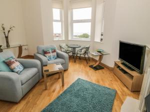 sala de estar con sofá y TV en Gwylanedd Two en Llanfairfechan