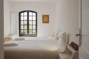 a white bedroom with two beds and a window at Altura LP Sunny House in Altura +32 photos