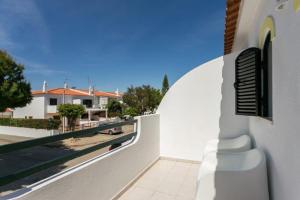 a white building with a balcony with a view of a beach at Altura LP Sunny House in Altura
