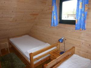 a bedroom with a bed in a wooden cabin at Ferienhaeuser Auszeit am Grossen Labussee in Userin