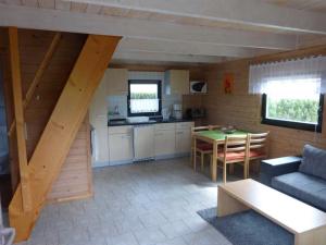 cocina y sala de estar con mesa y sofá en Ferienhaeuser Auszeit am Grossen Labussee, en Userin