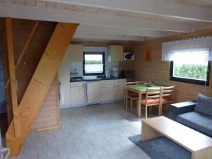 a kitchen and living room with a table and a couch at Ferienhaeuser Auszeit am Grossen Labussee in Userin