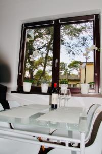 a table with two wine glasses and a window at Aqua Villa 4 in Jurata