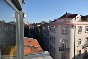 a view of the roofs of buildings from a window at Sunny Penthouse whith balcony 9min walk main station in Porto