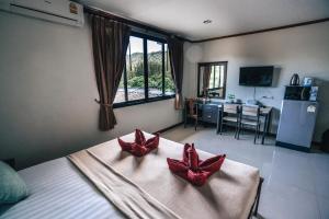 a bedroom with a bed with red bows on it at Phra Ae Apartments in Ko Lanta