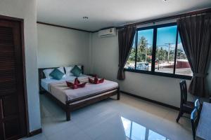 Een bed of bedden in een kamer bij Phra Ae Apartments