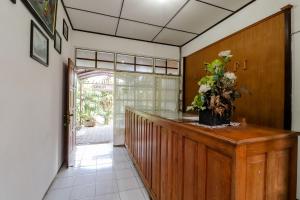 a hallway with a counter with a vase of flowers on it at Satriafi Hotel in Kaliurang