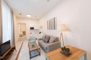 sala de estar con sofá y mesa en Céntriko Apartments Quintero 40, en Sevilla