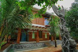 a house with a bird statue in front of it at Woodgreens Heritage Resorts in Kannur
