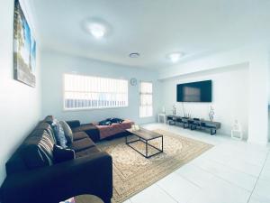 uma sala de estar com um sofá e uma mesa em Edmondson Villas Sydney em Horningsea Park