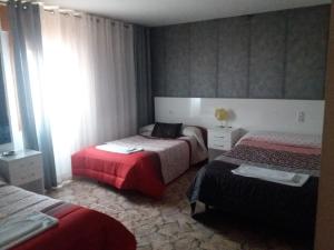 um quarto de hotel com duas camas e uma janela em Hostal Texas 2 em Fuentes de Ebro