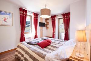 1 dormitorio con 1 cama grande y cortinas rojas en ETOILE LODGE en Hauteluce